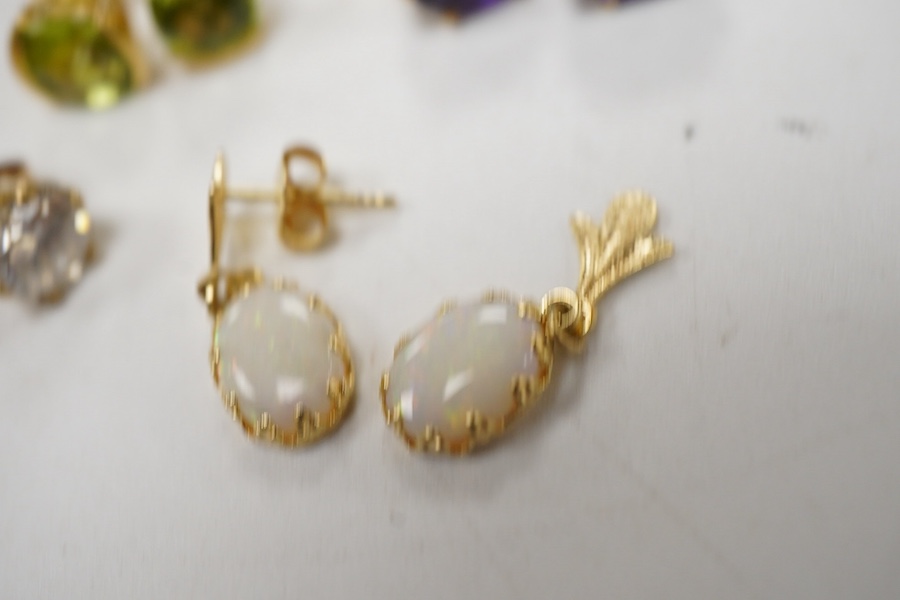 A pair of chequerboard cut peridot set 18ct stud earrings, a pair of amethyst set 9ct stud earrings and three costume pairs of earrings.